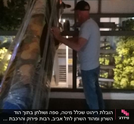 אדם מזיז חפץ גדול עטוף בניילון